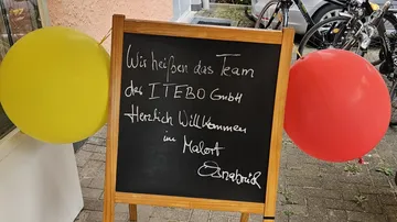 Chalkboard with welcome message, outside shop.