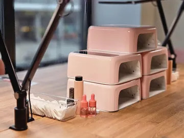 UV-Nagellampen auf Holztisch gestapelt.
