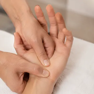 Hands giving a massage on wrist.