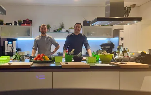 Two chefs standing in modern kitchen.