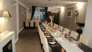 Elegantes Esszimmer mit langem, dekoriertem Tisch.