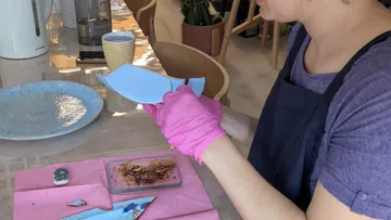 Person repairing broken plate at table