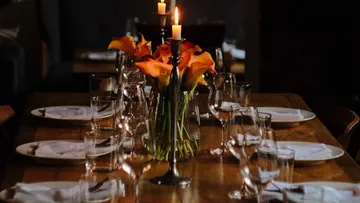 Candles and flowers on a set dining table.