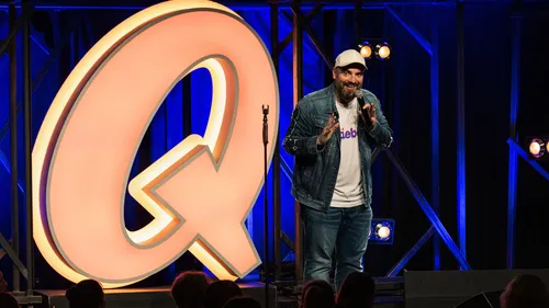 Komiker tritt auf Bühne vor Publikum auf.
