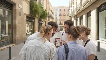 Gruppe schaut auf Handy in Stadtstraße.