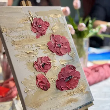 Textured painting of red flowers on canvas.