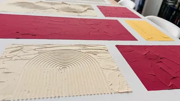 Texturiertes abstraktes Kunstwerk mit Farbfeldern.