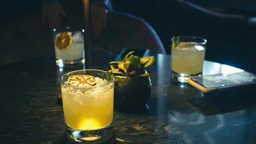 Cocktails auf einem schwach beleuchteten Tisch.