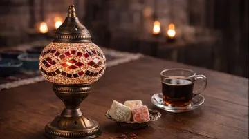 Ornate-Lampe auf Tisch mit Tee.