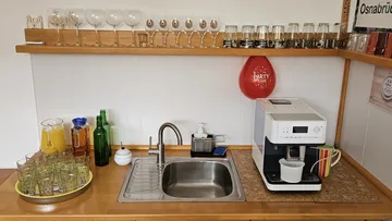 Kitchen counter with glasses and coffee maker.