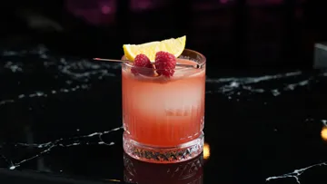 Roter Cocktail mit Himbeeren an der Bar.