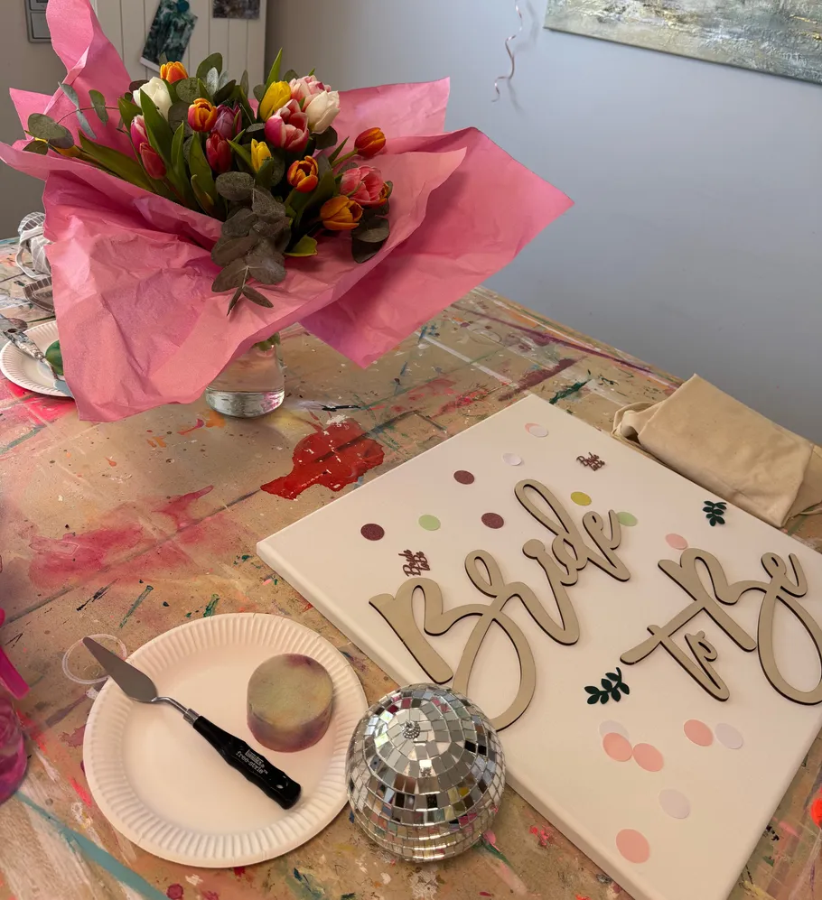 Flowers and "Bride to Be" sign on table.