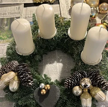 Advent wreath with candles on newspaper.