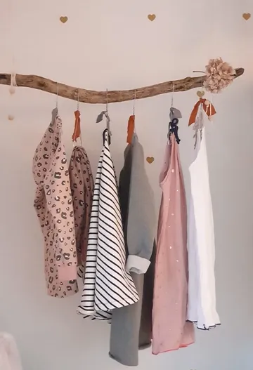 Clothes hanging on a branch indoors.
