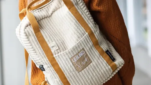 Rucksack mit Text, Person trägt Pullover.