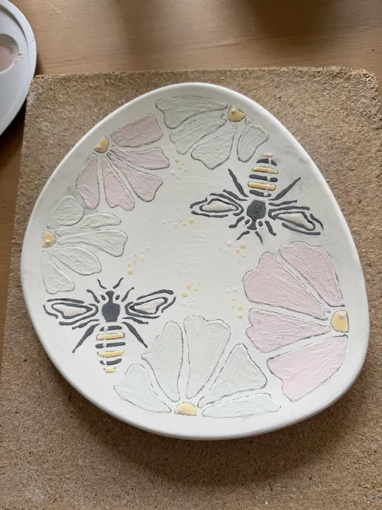 Teller mit Bienen- und Blumenmuster.