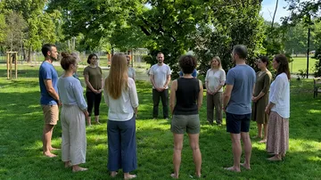 Menschen stehen im Kreis im Freien.