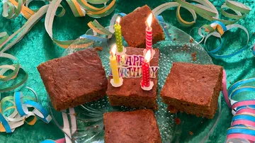 Kuchen mit Kerzen auf festlichem Tisch.