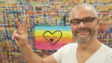 Mann macht Friedenszeichen, bunter Kunsthintergrund.