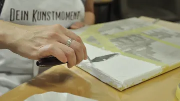 Hand painting canvas with white spreader.