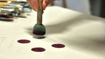 Hand stempelt Kreise auf weißem Papier.