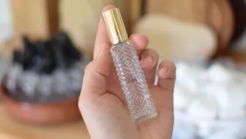 Hand holding a decorative perfume bottle.