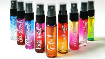 Colorful spray bottles with written labels, arranged upright.