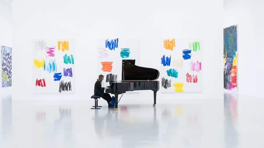 Person playing piano in art gallery.