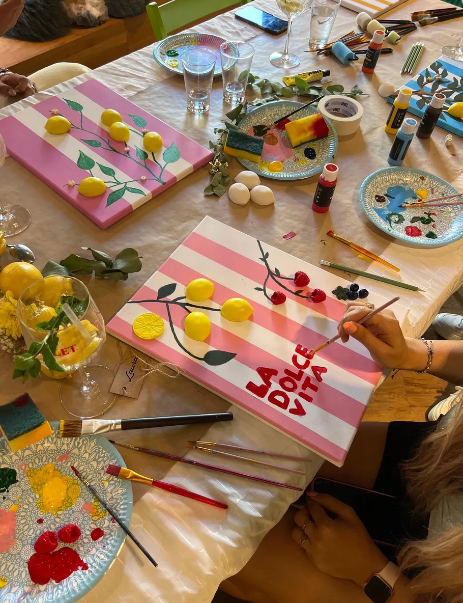 Person painting canvas at art table.