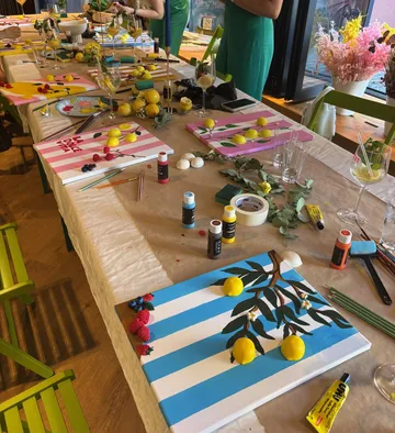 Kunstbedarf auf Tisch mit Gemälden, Zitronen.