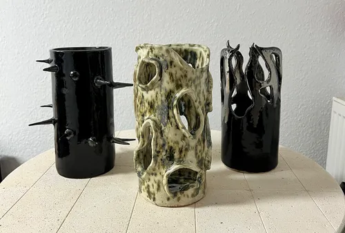 Three artistic vases on a round table.