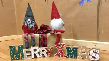 Zwei Wichtel sitzen auf einem Geschenk.