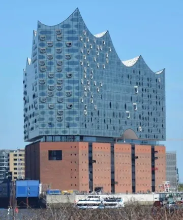 Modern building with glass facade by waterfront.