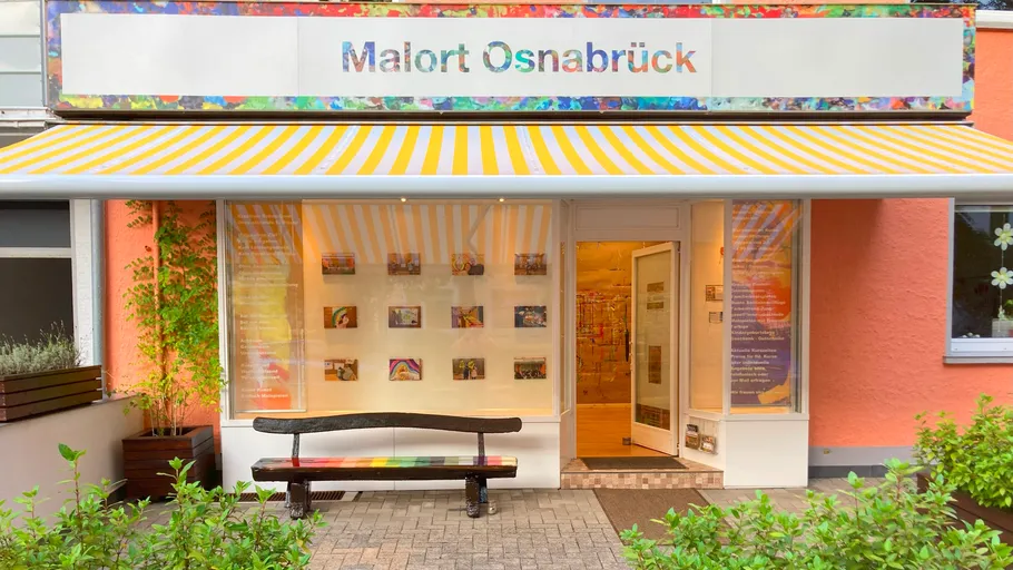 Art studio entrance with yellow-striped awning.