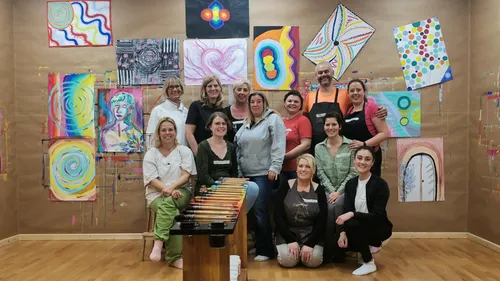 Group of people posing in art studio.