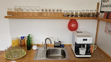 Kitchen sink with glasses and coffee maker.