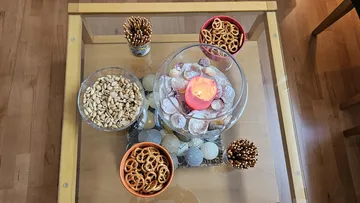 Snacks and candle on glass table.