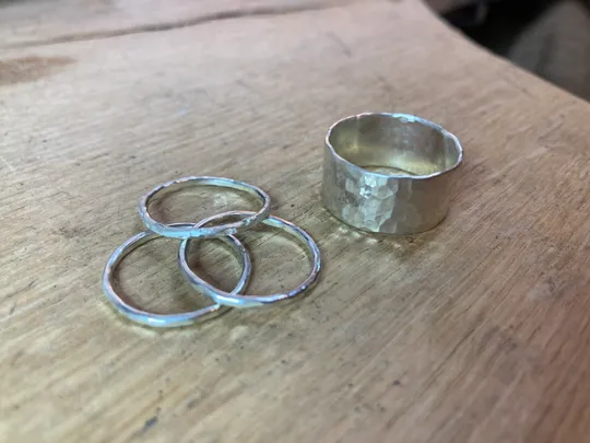 Ringe liegen auf einem Holztisch.