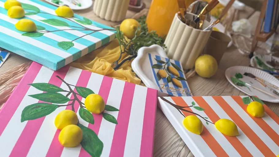 Paintings of lemons on striped canvases.