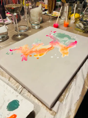 Canvas with abstract paint, surrounded by drinks.