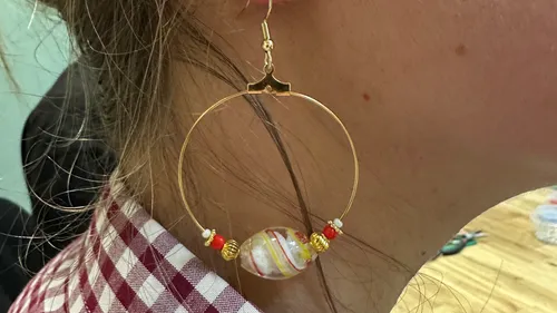 Ohrring mit buntem Perle am Ohr getragen.