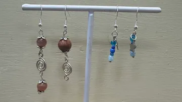 Earrings displayed on a white stand.