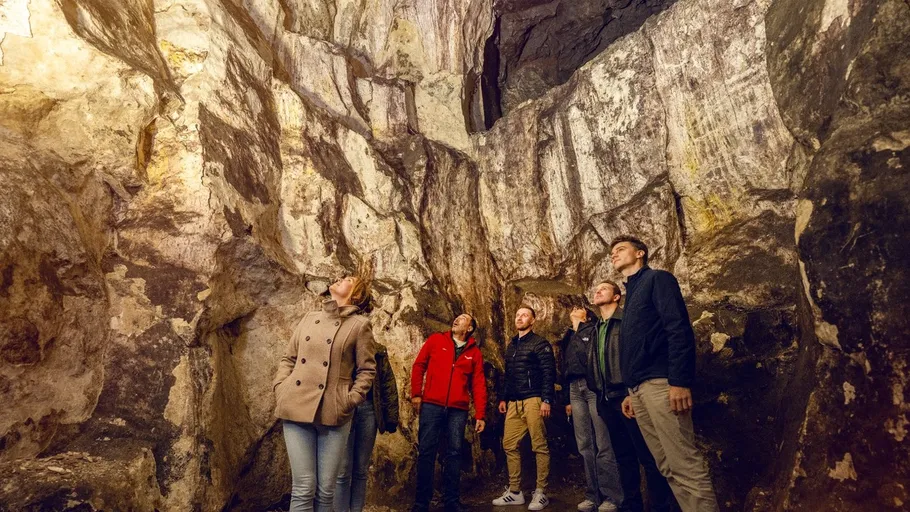 Fünf Personen erkunden eine Höhle.