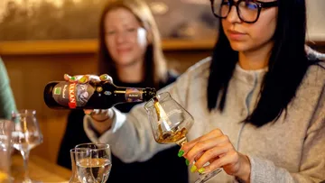 Frau schenkt Bier in einem Pub ein.
