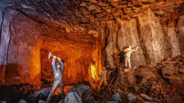 Bergleute graben in einer unterirdischen Höhle.