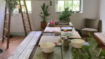 Rustikale Küche mit Pflanzen und Holztisch.