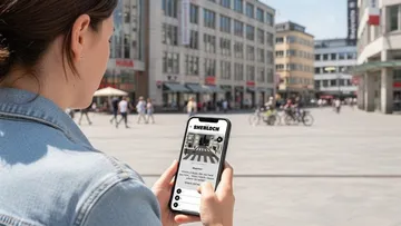 Person using phone in a city square.