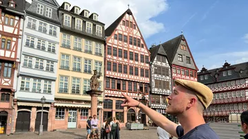 Person zeigt auf historische europäische Gebäude.