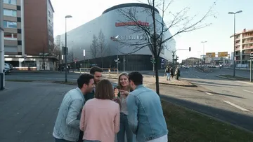 Group using phone on urban sidewalk.