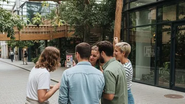 Gruppe schaut auf Handy im Freien.